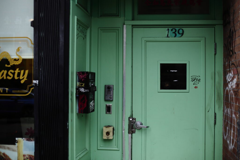 The mint green entrance to a residential building in Vancouver's Chinatown.